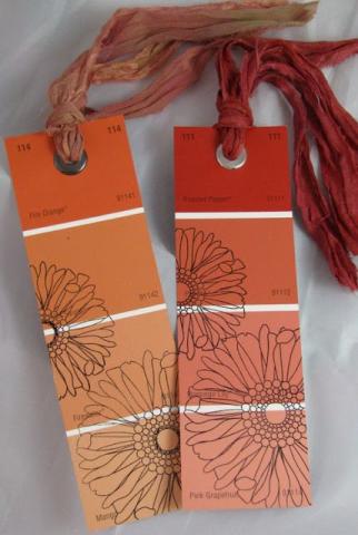 orange paint swatch bookmarks with flowers and a tassel. 