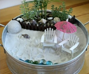 container with sand, beach chairs and rocks