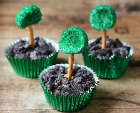 Dirt pudding snacks with crushed cookies and pretzel marshmallow trees