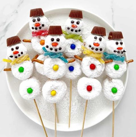 Image of powdered donut holes and candy making snow men figures