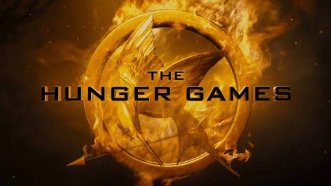 Hunger Games text over flaming mockingjay symbol