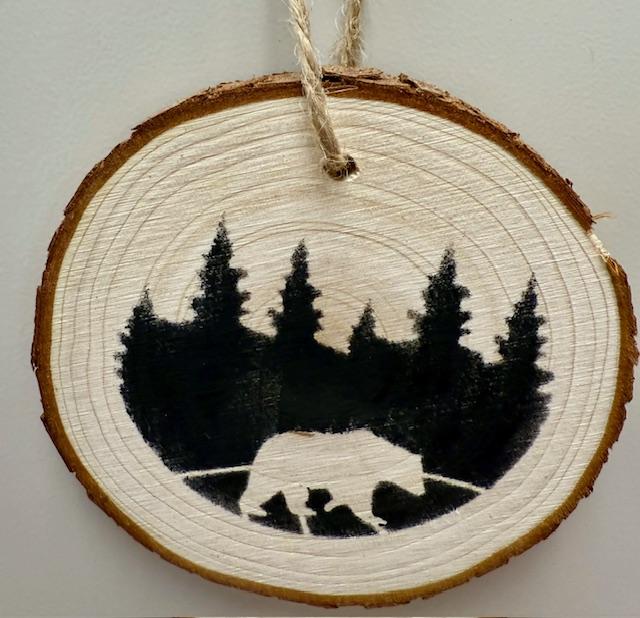 bear and trees stenciled onto a wood round