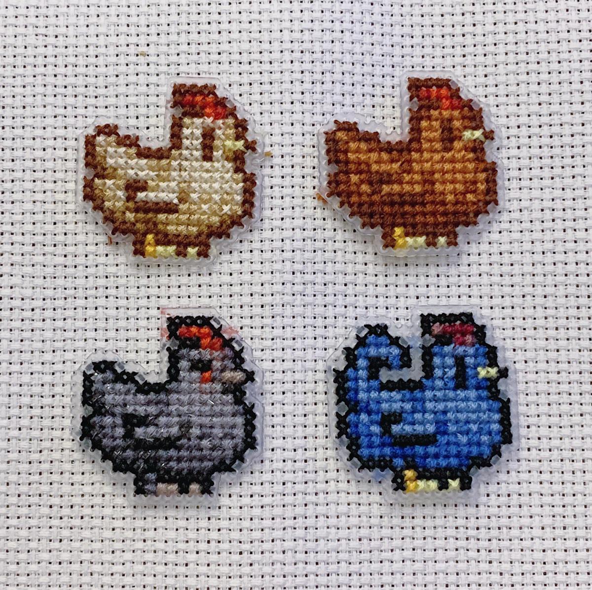 one of each stardew valley chickens cross stitched on fabric