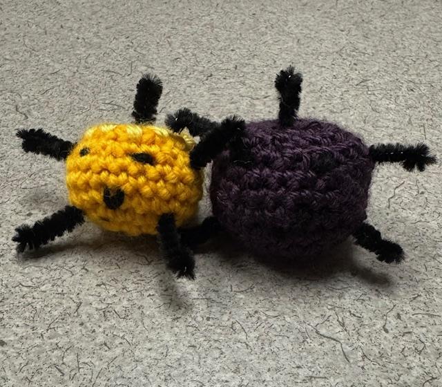 a yellow and dark purple crochet Junimo