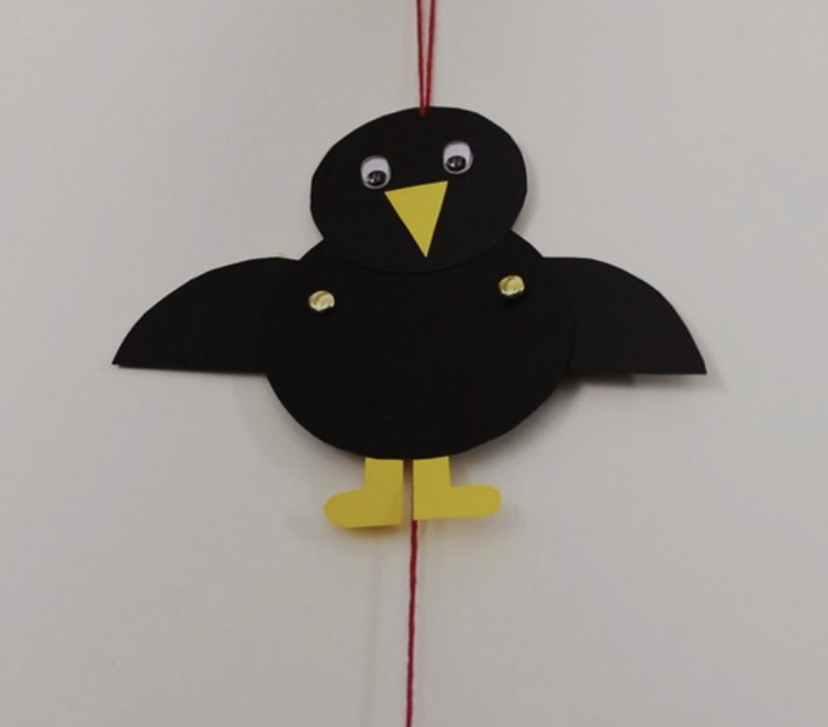 Paper crow on a string